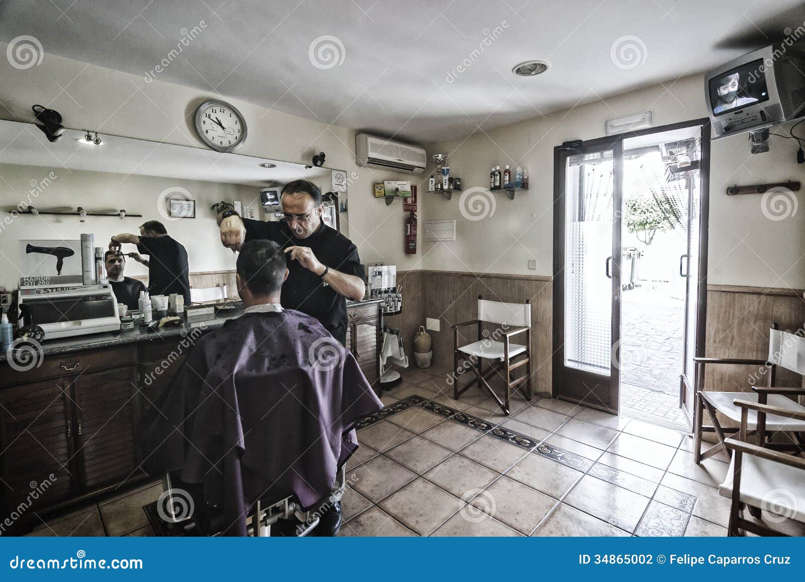 Barber Shaving With A Razor To Young Man In A Barber's 