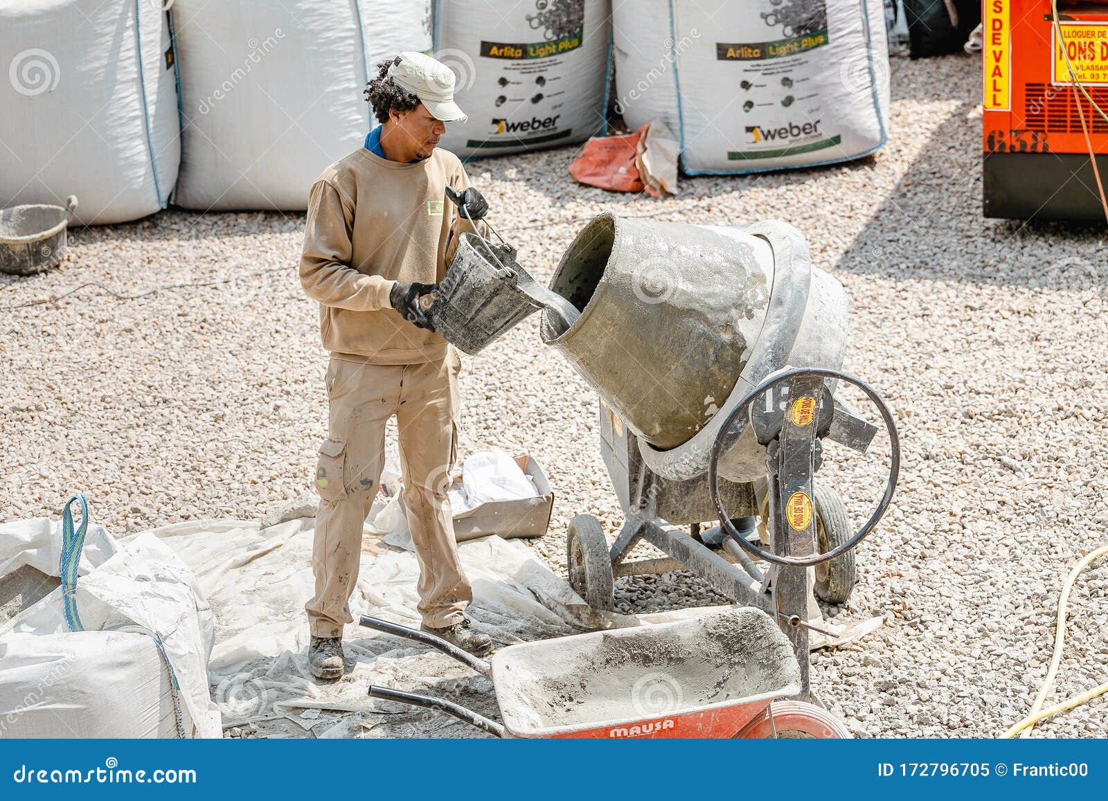 Builder Man Working with Concrete Cement Mixer at Construction Site