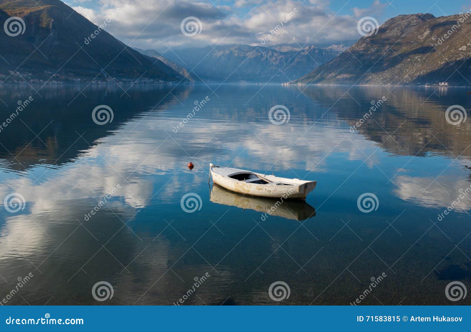 Barco branco em claro calmo completamente da água do céu com fundo das montanhas