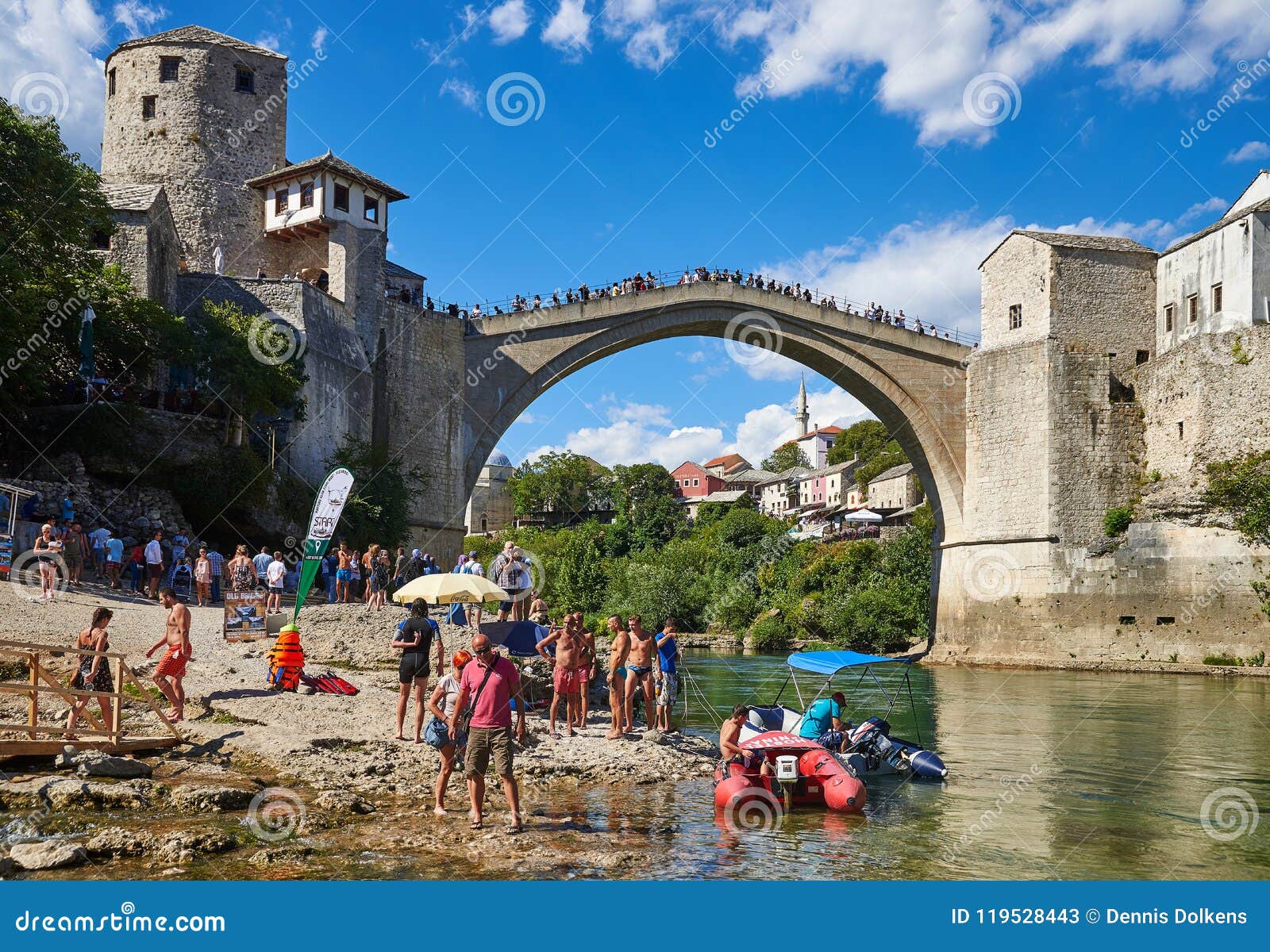 Barcos e turistas debaixo de Stari mais em Mostar. Vista na ponte velha Stari mais através do rio de Neretva em Mostar, em Bósnia e em Herzegovina