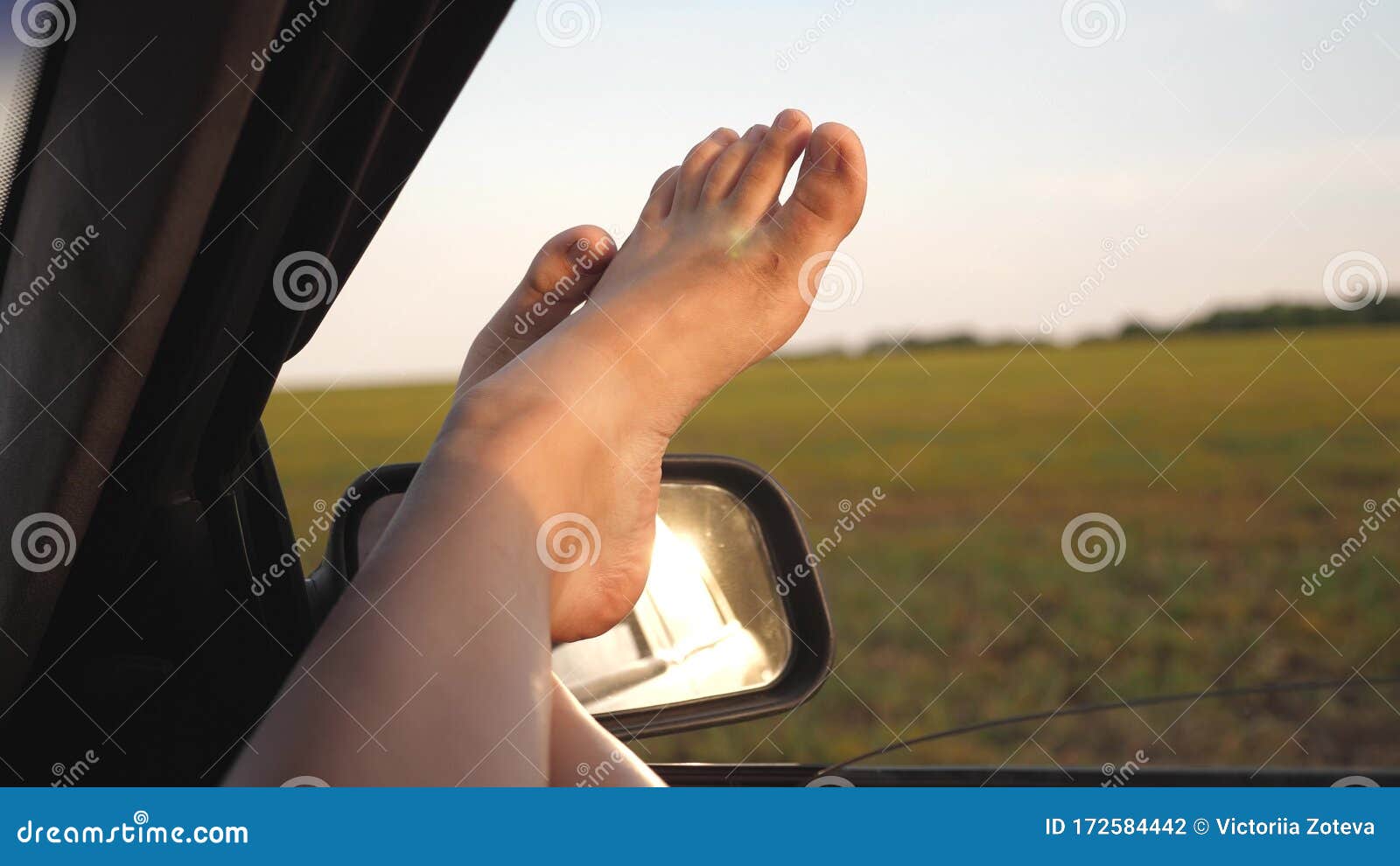 Bare Feet Of A Girl In A Car Window Glare Of The Sun