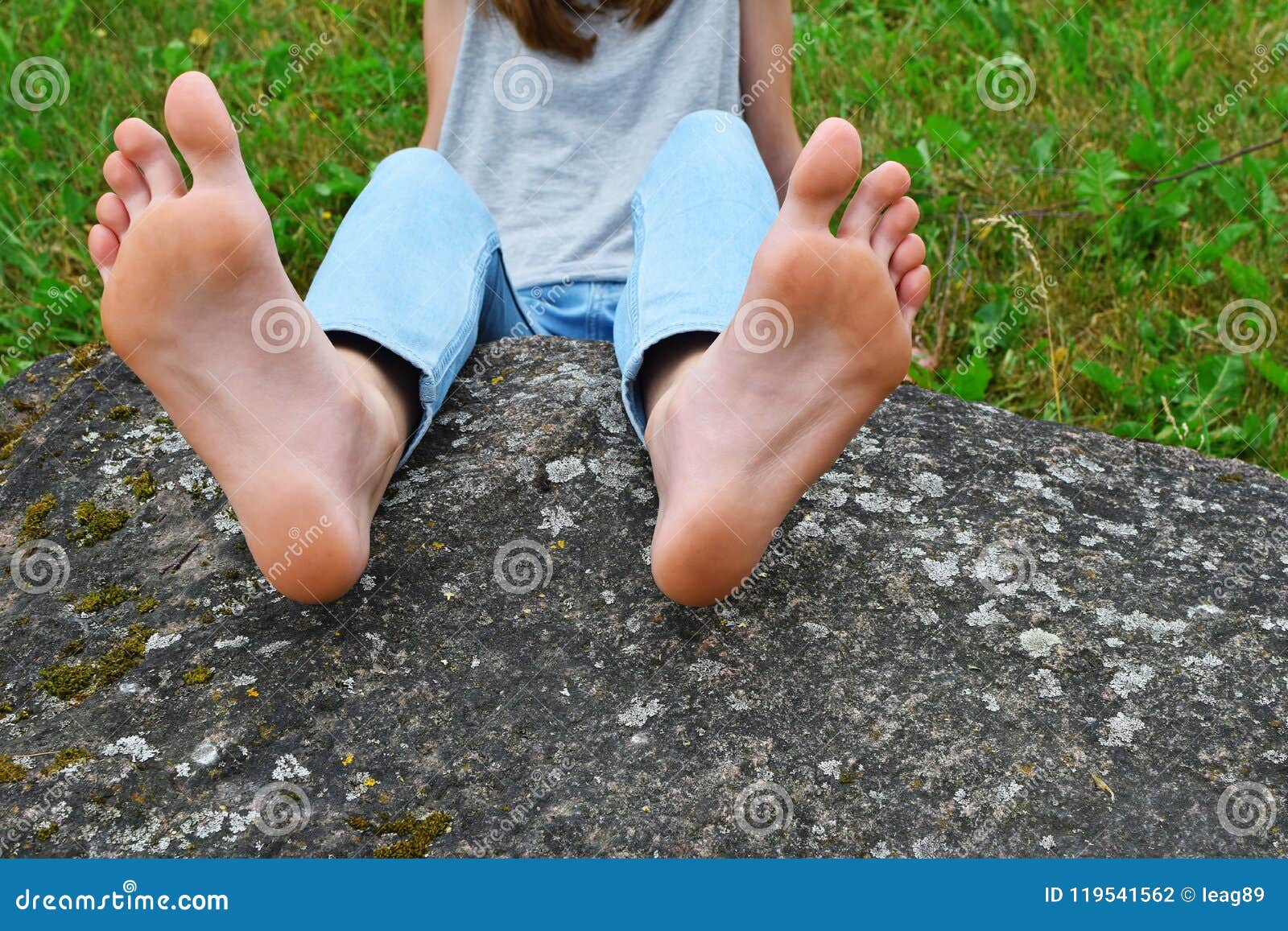 Bare feet of girl on stone stock photo 