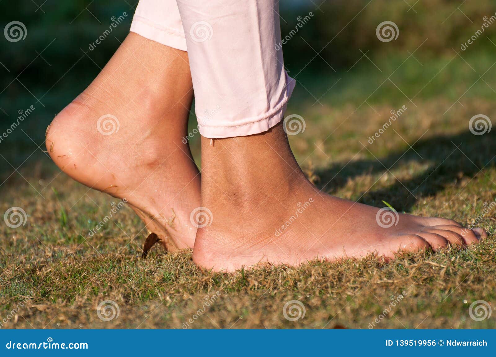 A Girl is Walking on the Wet Grass Stock Photo Image of happy, barefoot 139519956