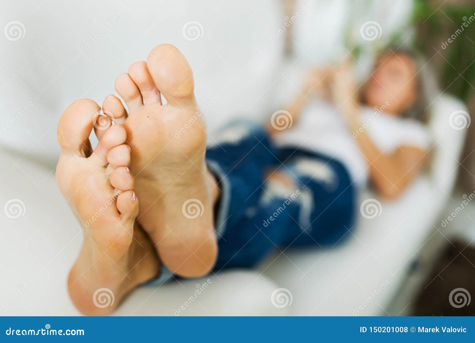 bare feet of woman in jeans using smart phone.bare foot