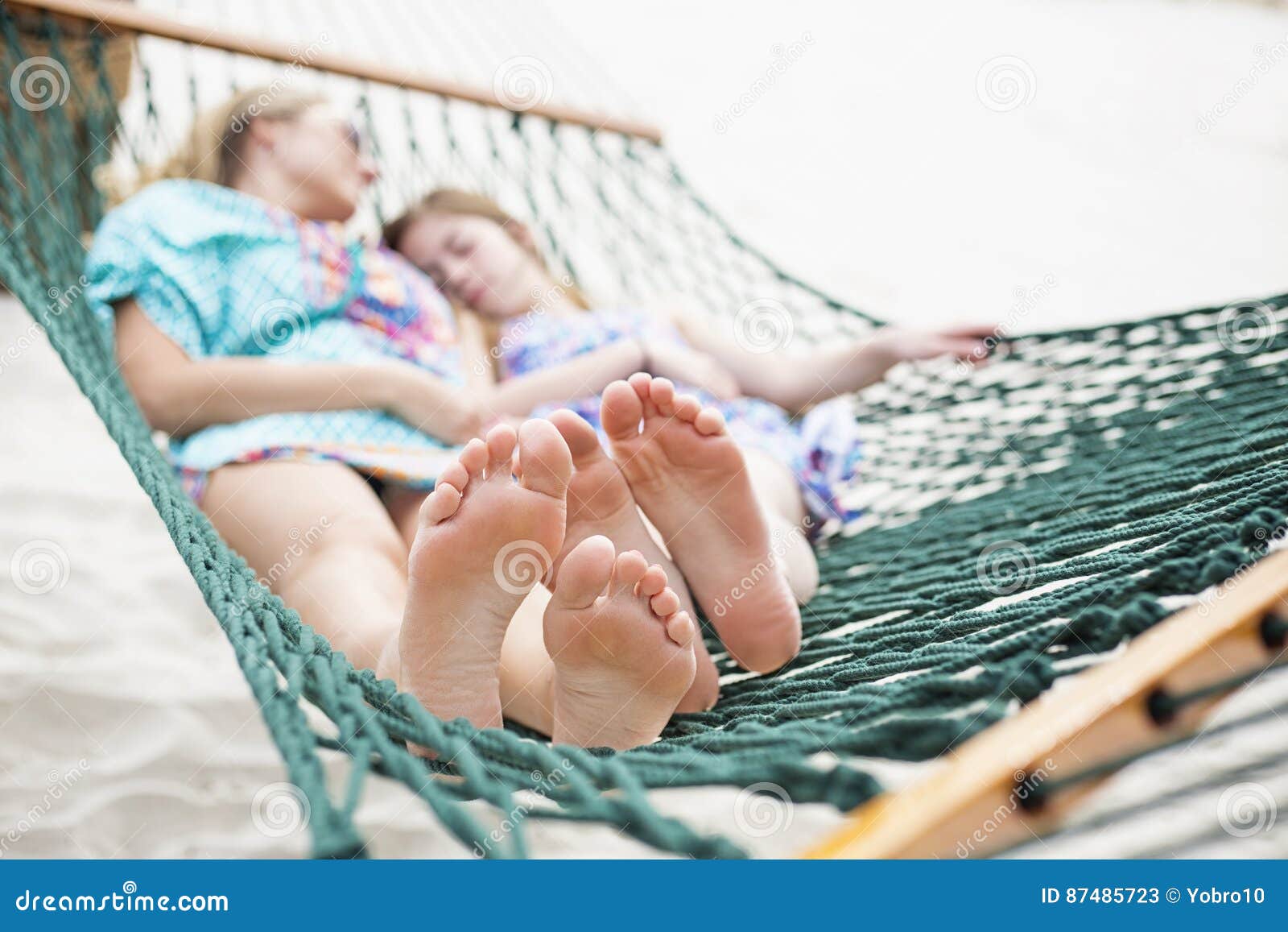 barefoot and relaxed family napping in a hammock together
