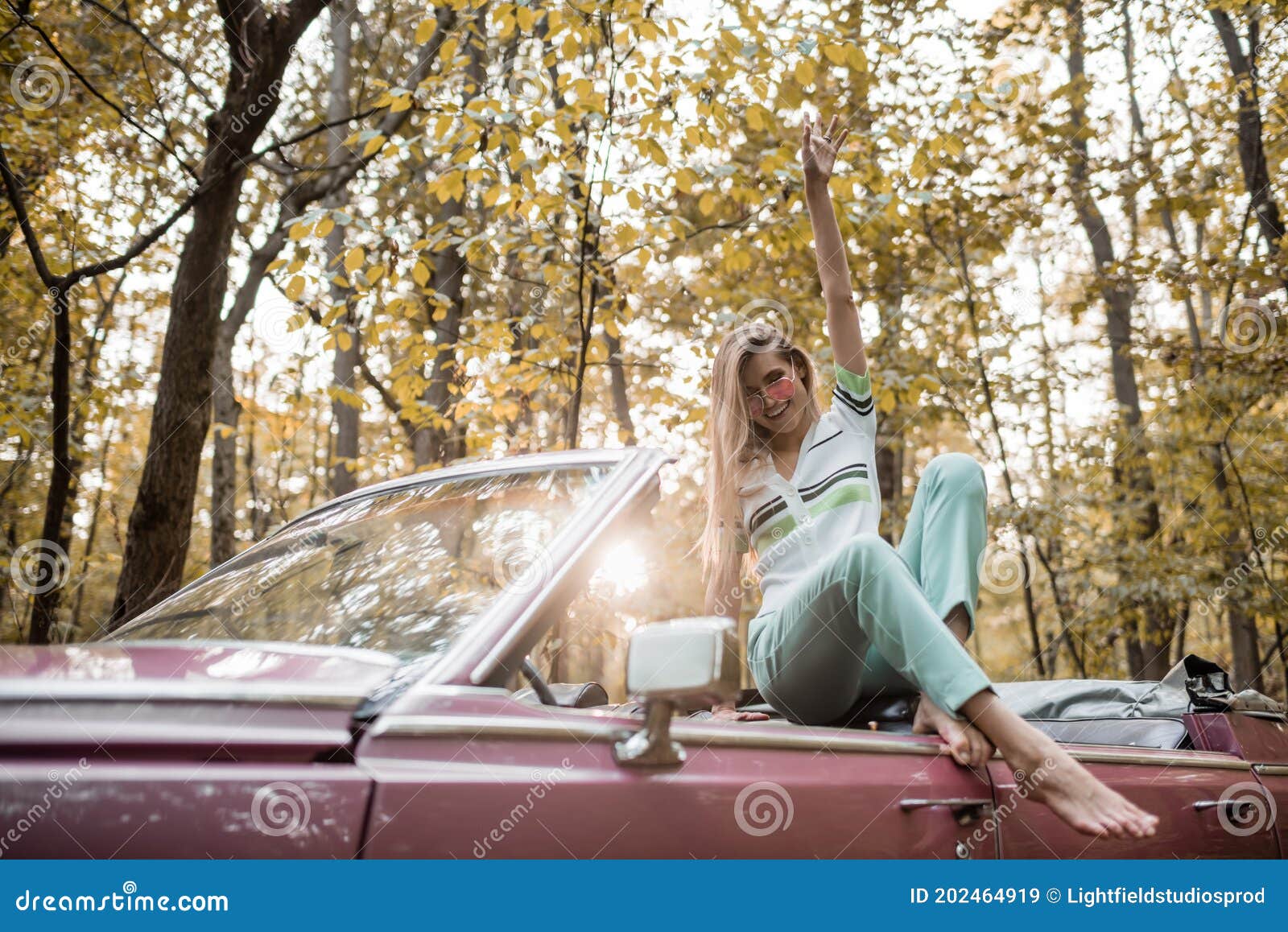 https://thumbs.dreamstime.com/z/barefoot-woman-looking-camera-joyful-barefoot-woman-looking-camera-posing-hand-air-cabriolet-202464919.jpg