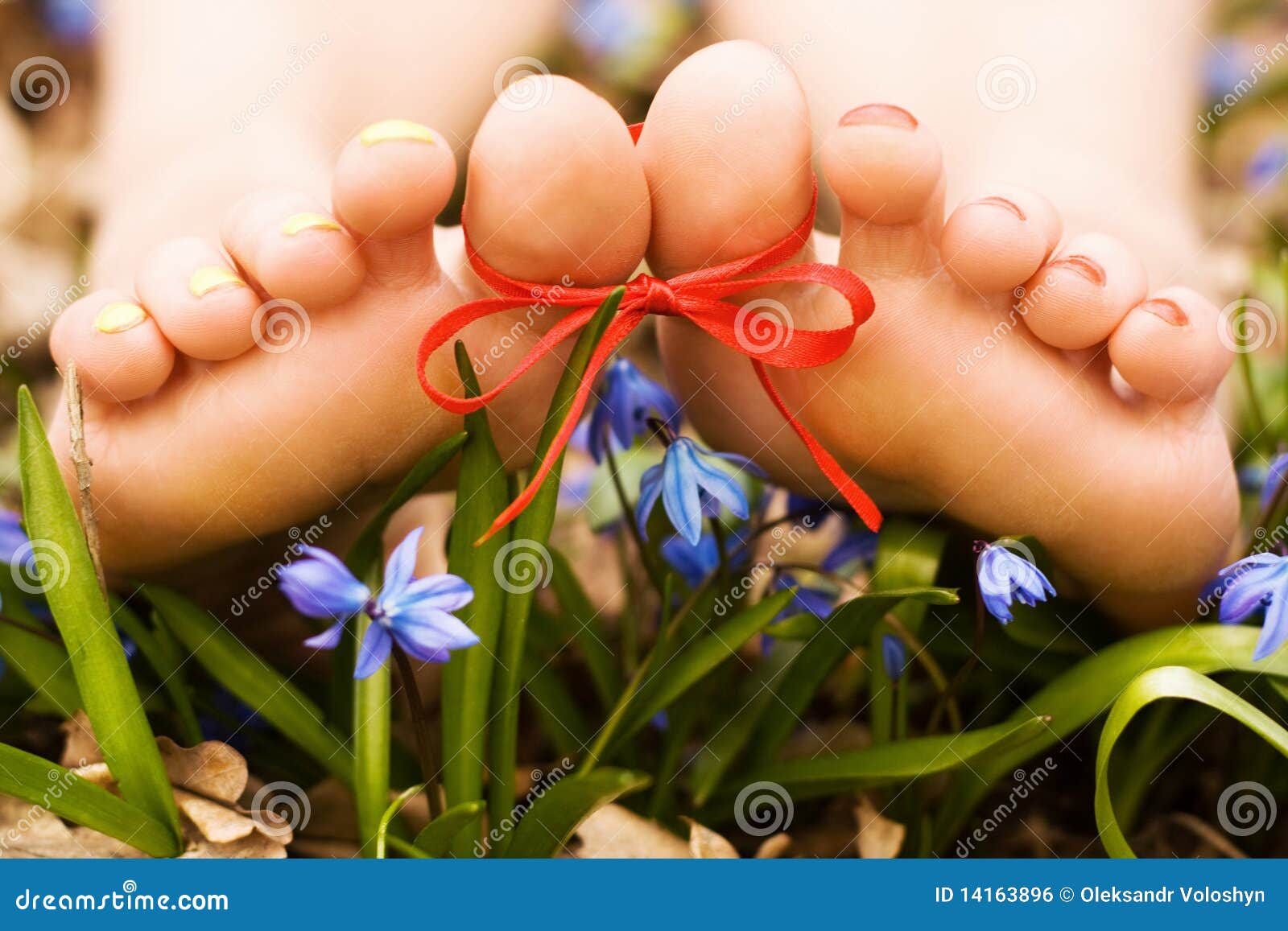 barefooted woman's feet in flowers. ribbon bow