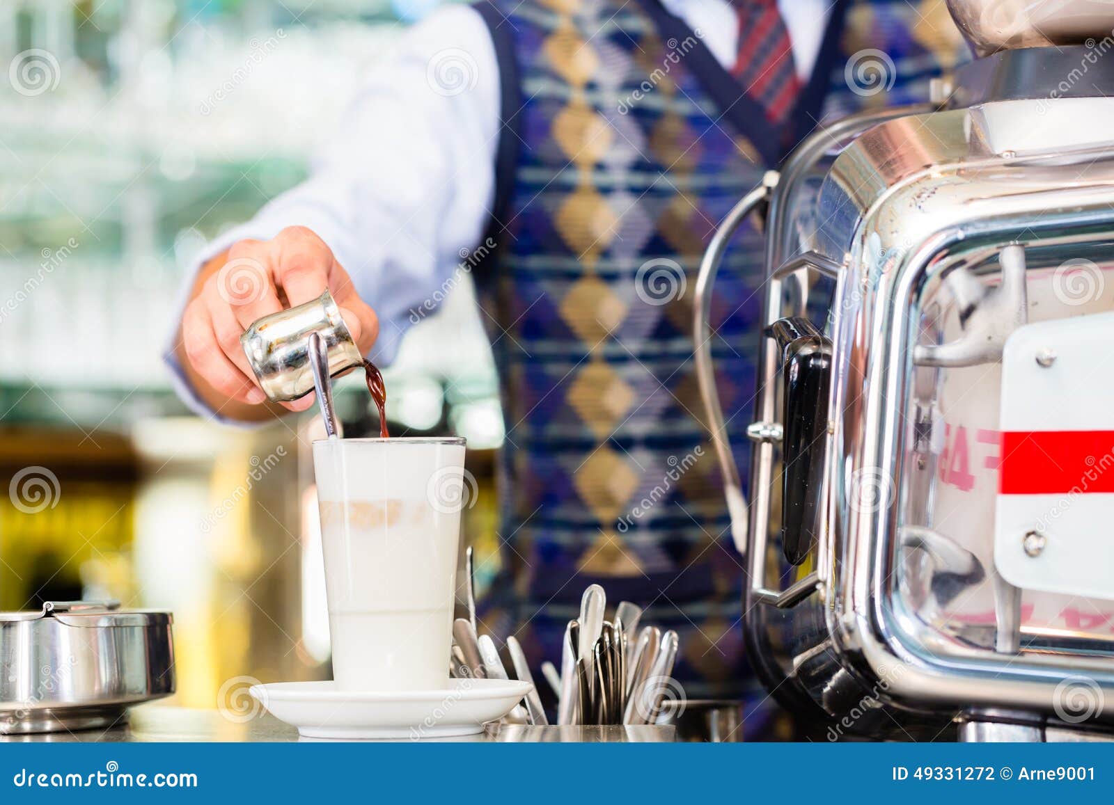 barista in cafe pouring espresso shot in latte macchiato