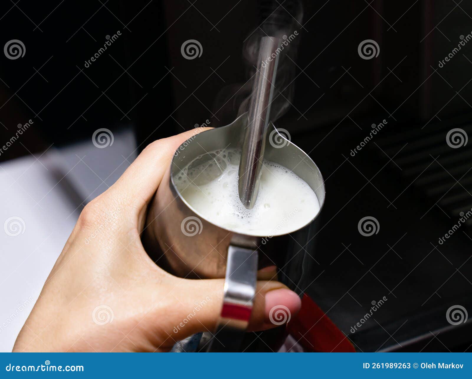 barista girl froths milk on a coffee machine for making cappuccino or latte. the concept of making drinks from natural coffee.