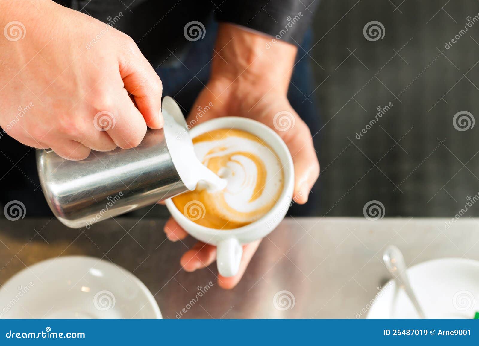 barista making cappuccino in his coffeeshop