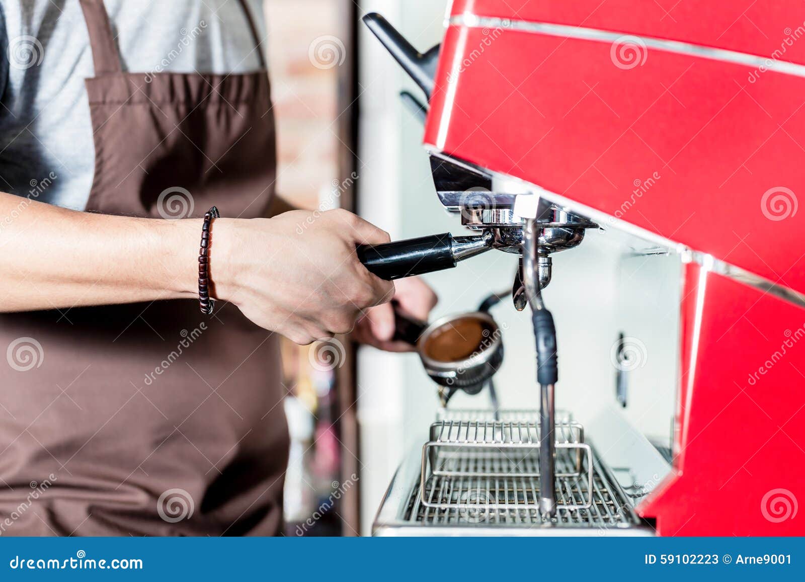 barista preparing coffee on portafilter machine in cafe