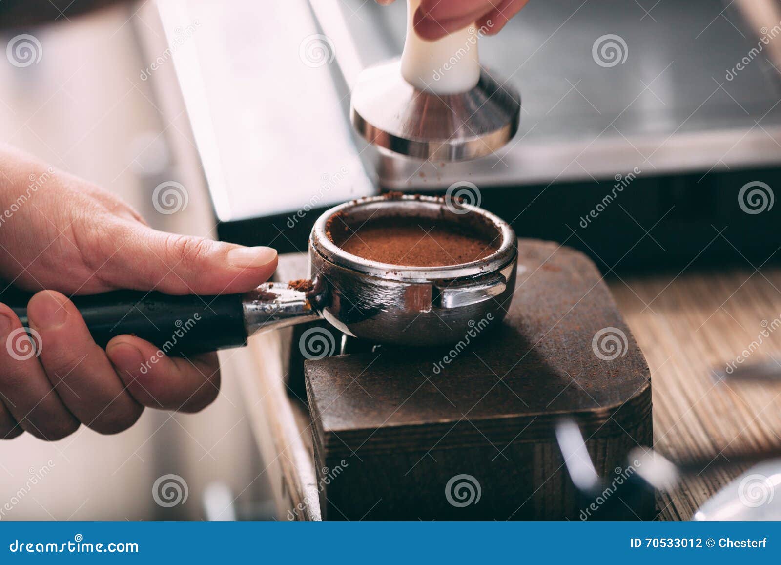 barista pressing coffee in the machine holder