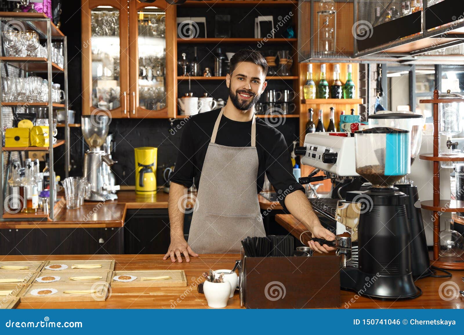 Barista que vierte el café molido de la máquina de pulir en portafilter en café