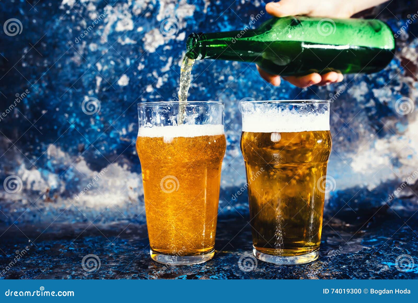 Barman with Beer Bottle Pouring a Draught Lager Beer Stock Photo
