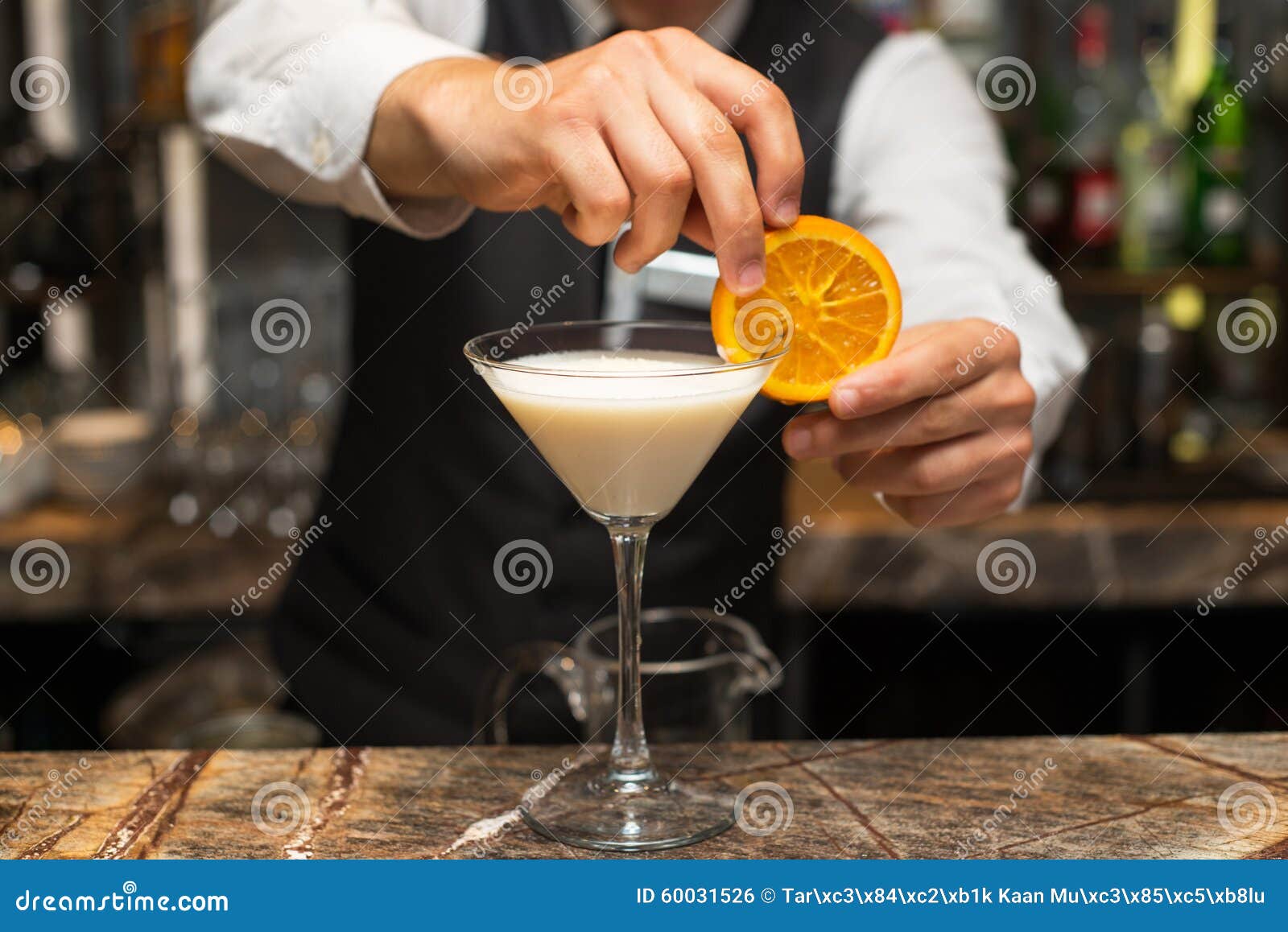 barman at work, preparing cocktails. pouring pina colada to cocktail glass.