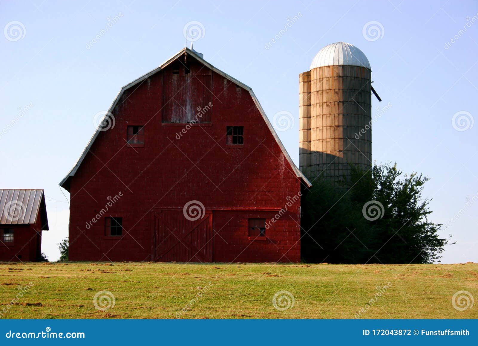 barn and silo against blue sky