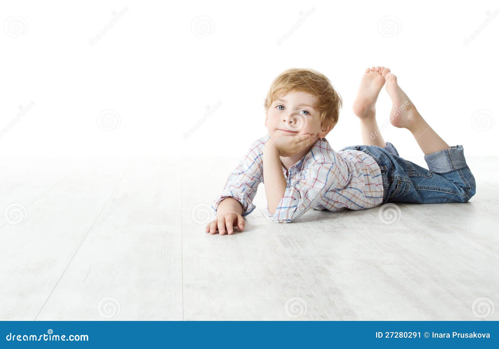 Barn som ner ligger på golv och ser kameran. Kopiera avstånd