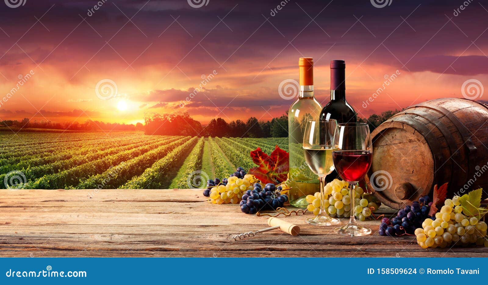 barrel wineglasses and bottle in vineyard