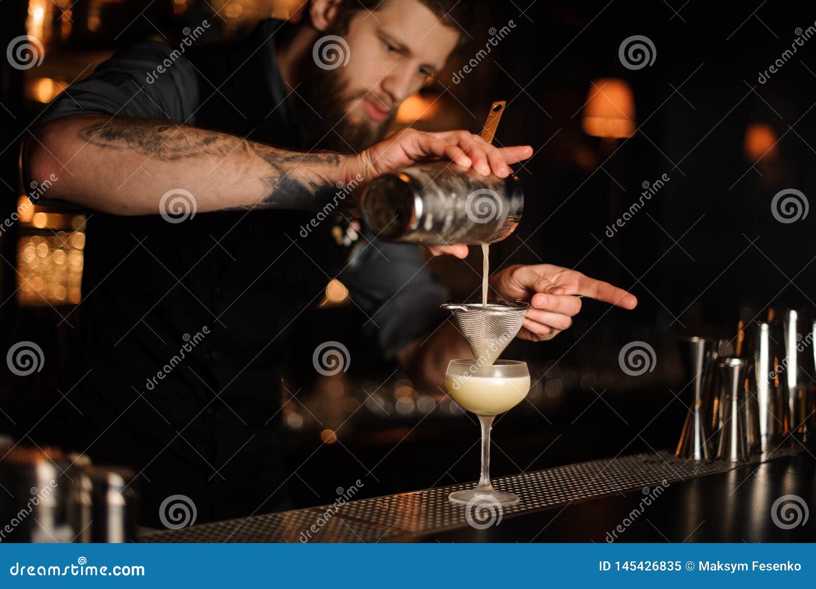 Bartender Adds Sour Mix in Alcohol Cocktail Using Shaker and Sieve