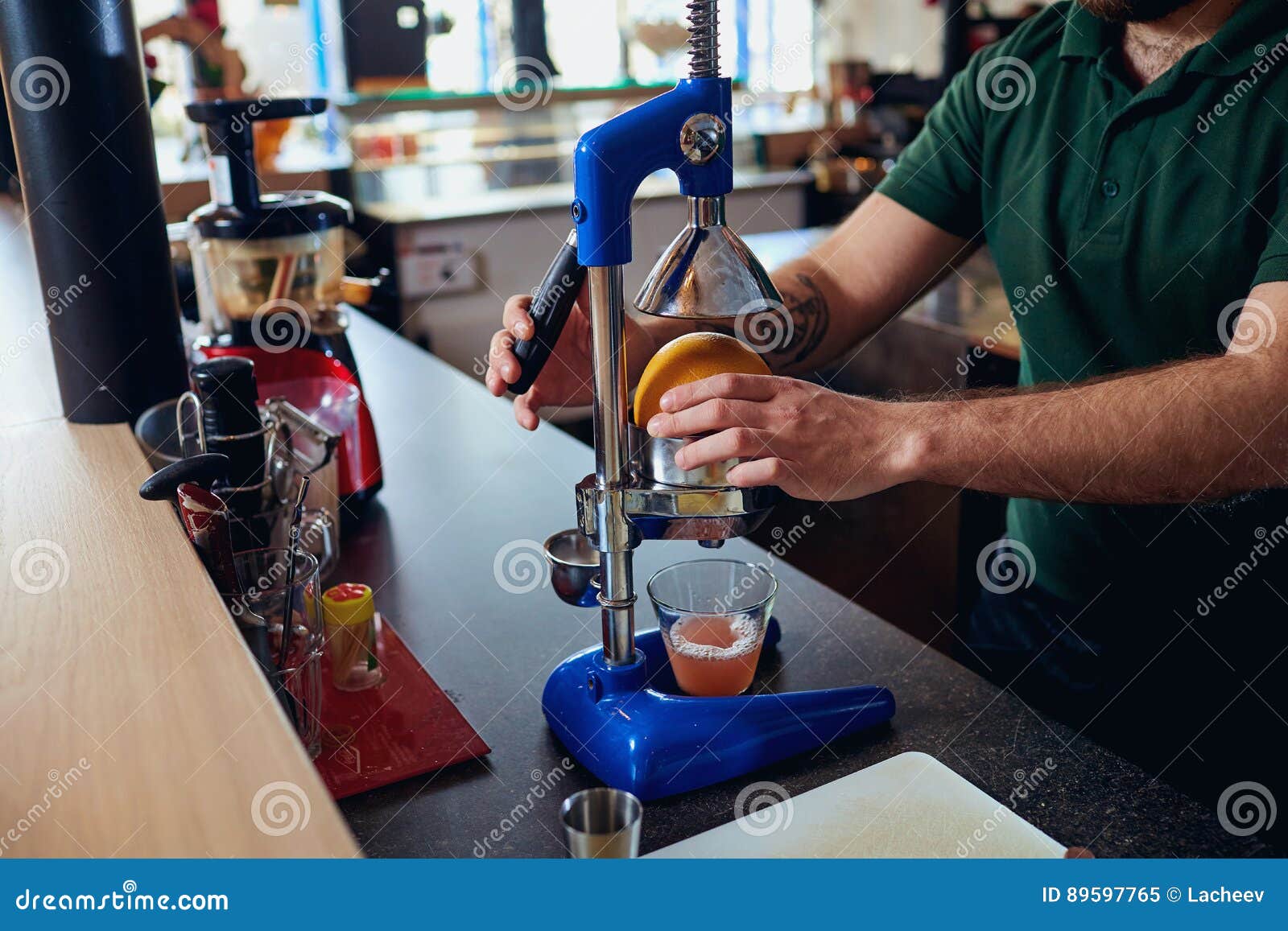 The Bartender Barista Makes Freshly Squeezed Juice on Machine Pr Stock