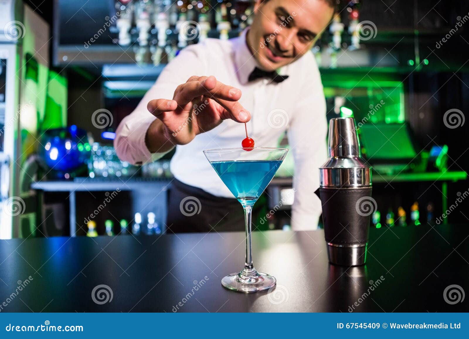 bartender garnishing cocktail with cherry