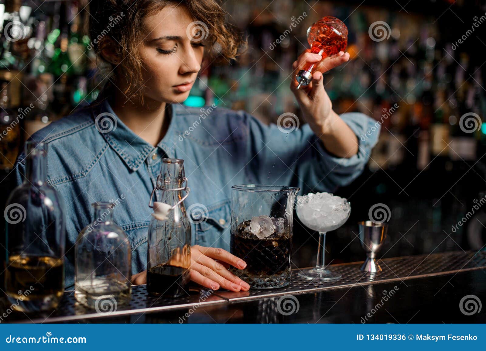 Bartender Girl Pouring To the Measuring Cup with Ice Cubes a Red Bitter ...