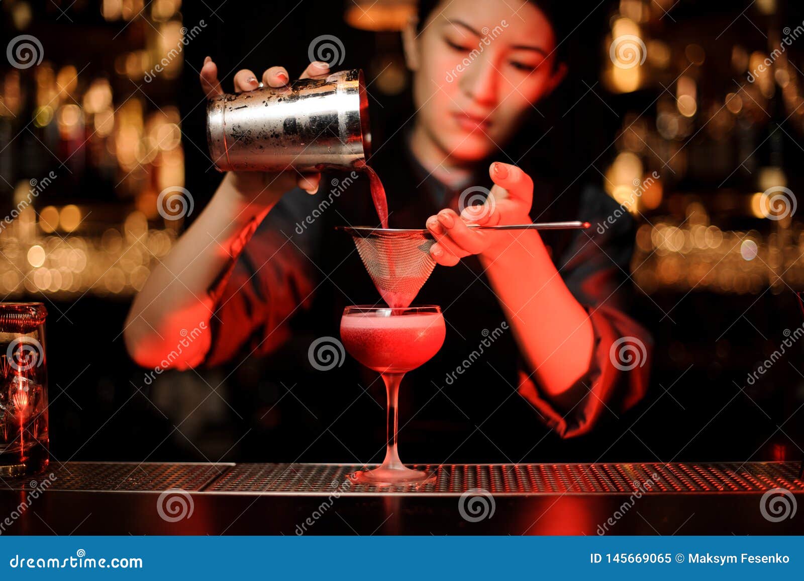 Bartender Pouring Cocktail Using Shaker and Sieve Highlighted in Red ...