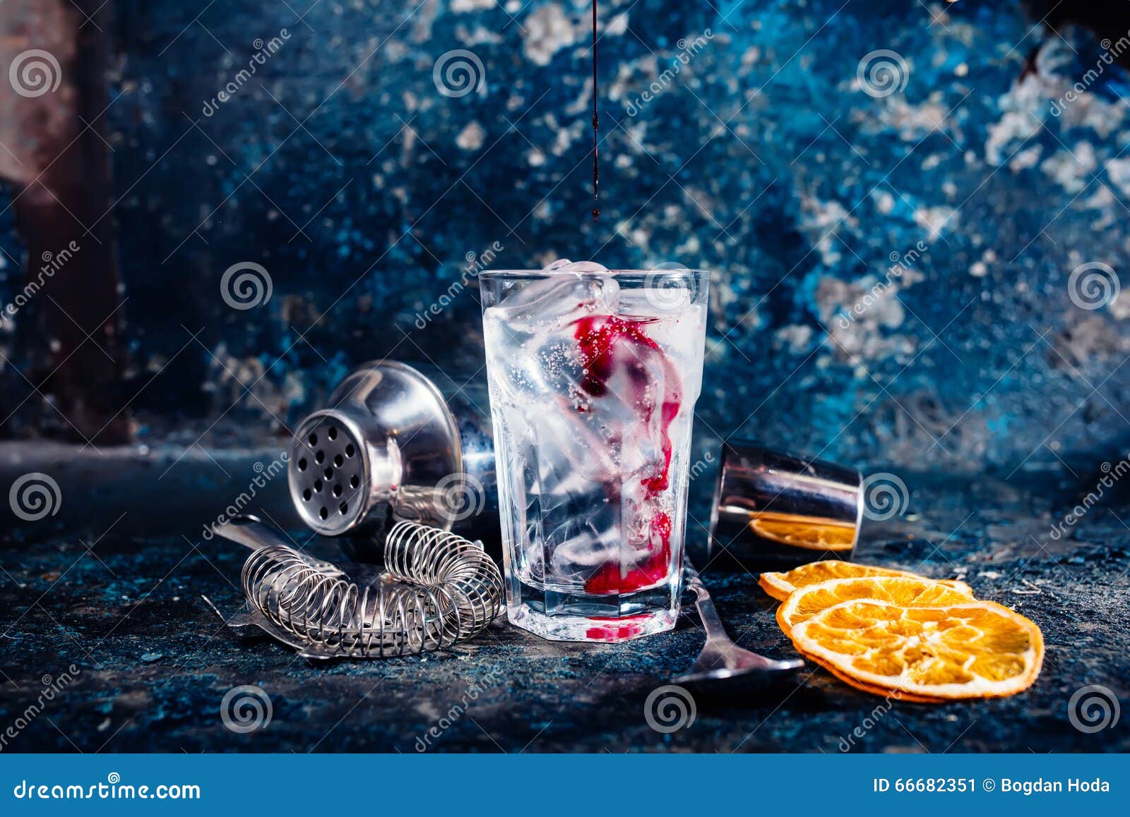 bartender pouring cranberry juice over vodka cocktail