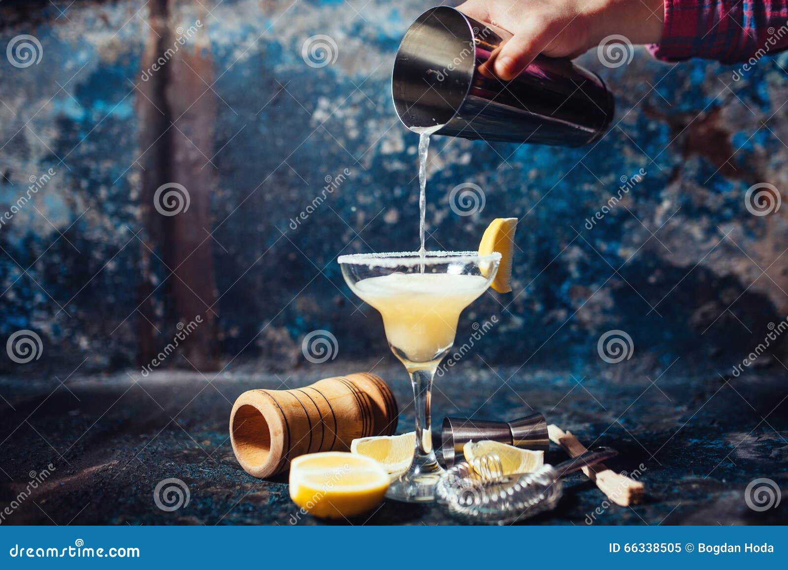 bartender pouring lime margarita in fancy glass at restaurant