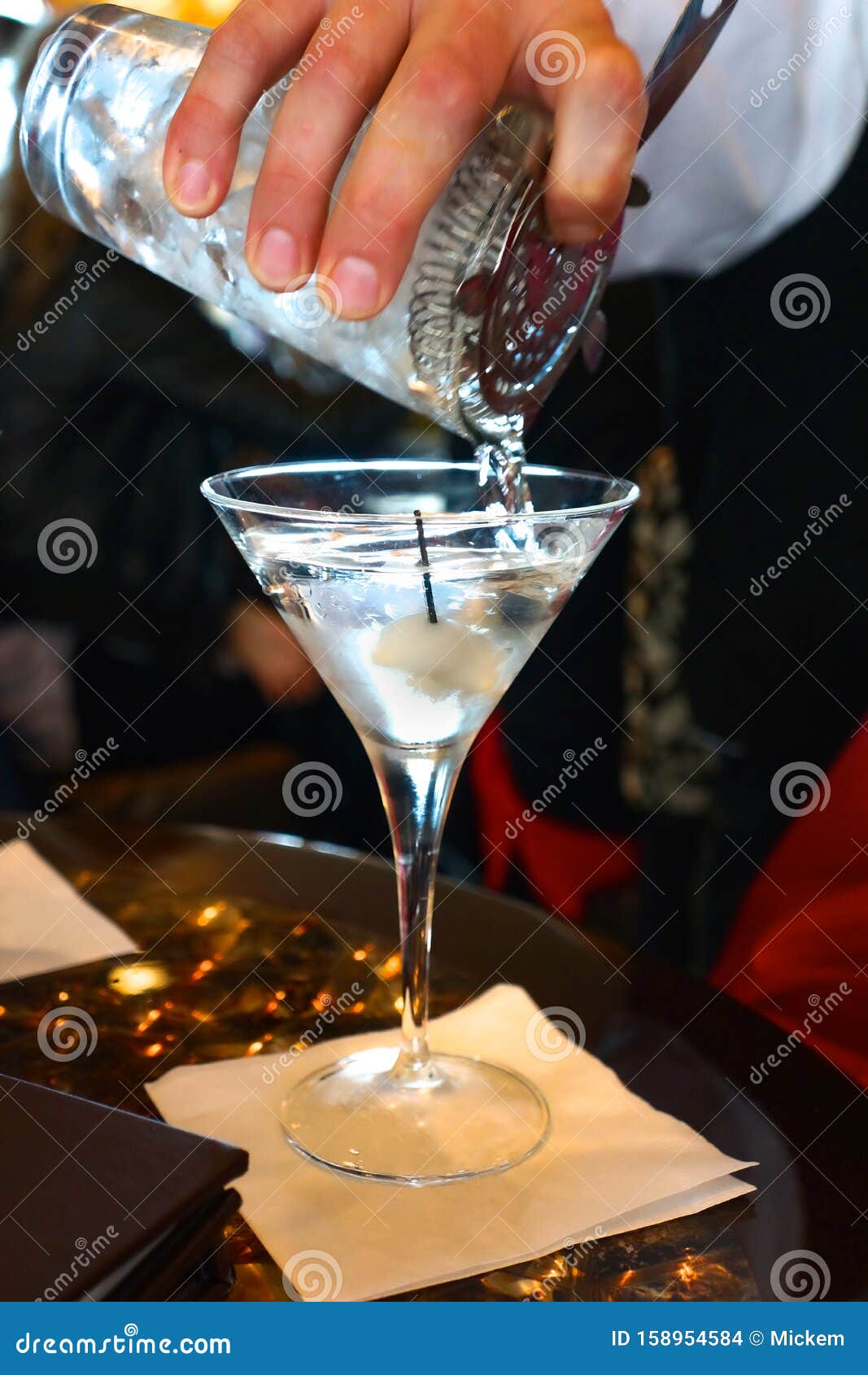 bartender pours martini cocktail drink vertical
