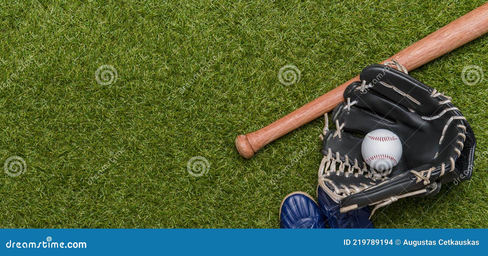 baseball bat, shoes, glove and ball on green grass field. sport theme background with copy space for text and advertisment
