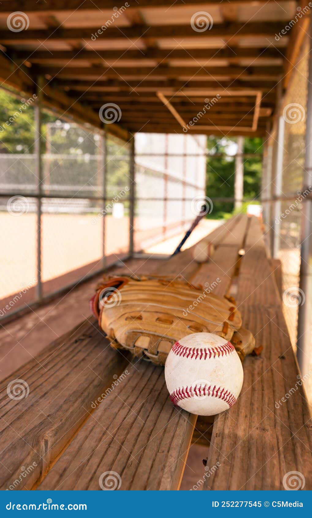 Baseball with Glove on Dugout Bench with Blurred Background Stock Image
