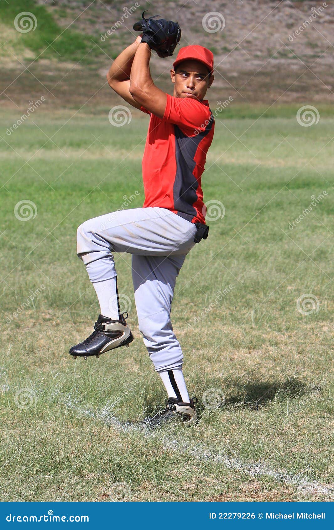 baseball pitcher winds up to throw the ball