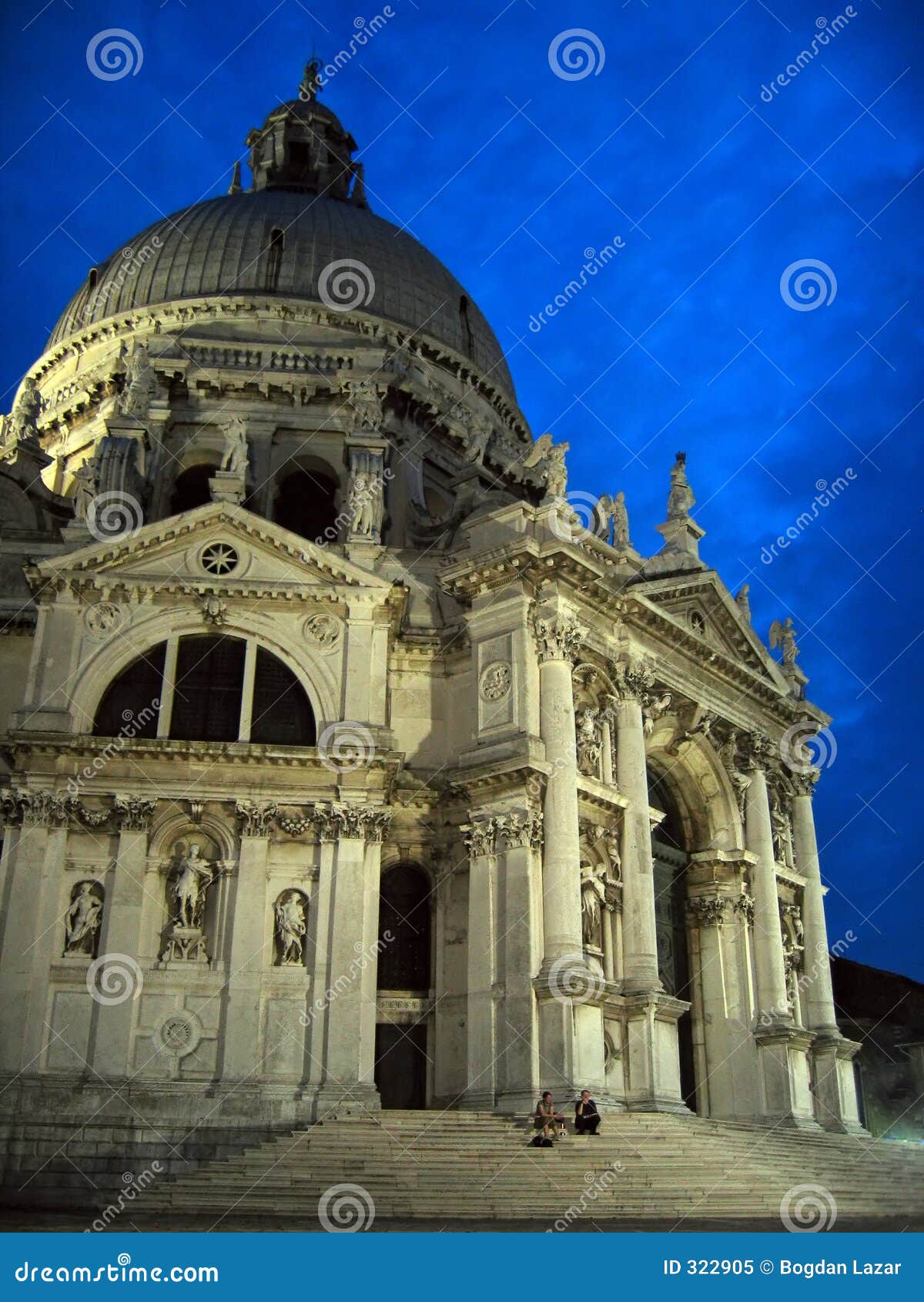 Basilika della Gruß â Venedig, Italien. Der majestätische Basilika della Gruß, Baldassarre Longhenaâs barockes Meisterwerk, aufgebaut, um das Ende der Pest in 1630 Standplätzen im Bassin nahe dem Anfang des großartigen Kanals zu gedenken. Die Kirche, aufgebaut auf einem achteckigen Plan, wird durch ein polygonales Treppenhaus erreicht, das um das faÃ§ade einwickelt. Überrascht erleichtern Sie unter dem blauen Himmel der Dämmerung.