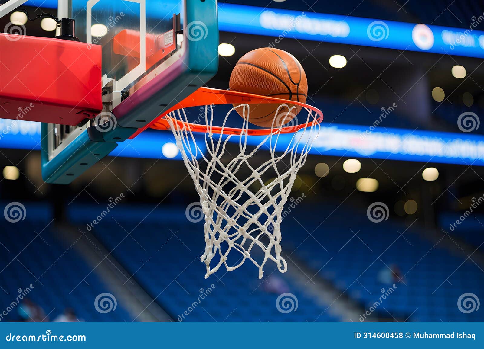 basketball going into hoop with colorful stadium bokeh background
