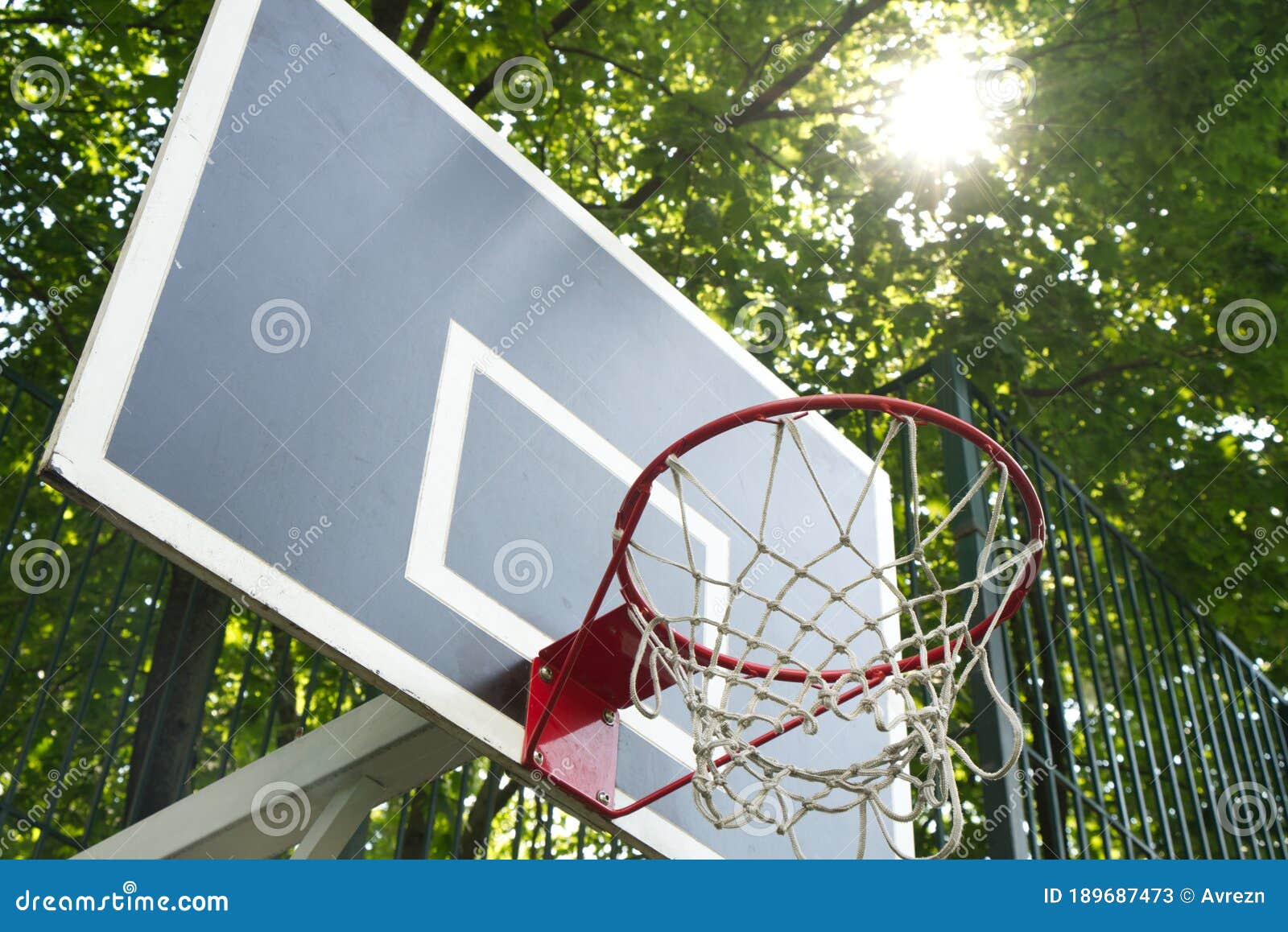 Basketball Hoop in the Rays of Breaking Light in the Yard Stock Image