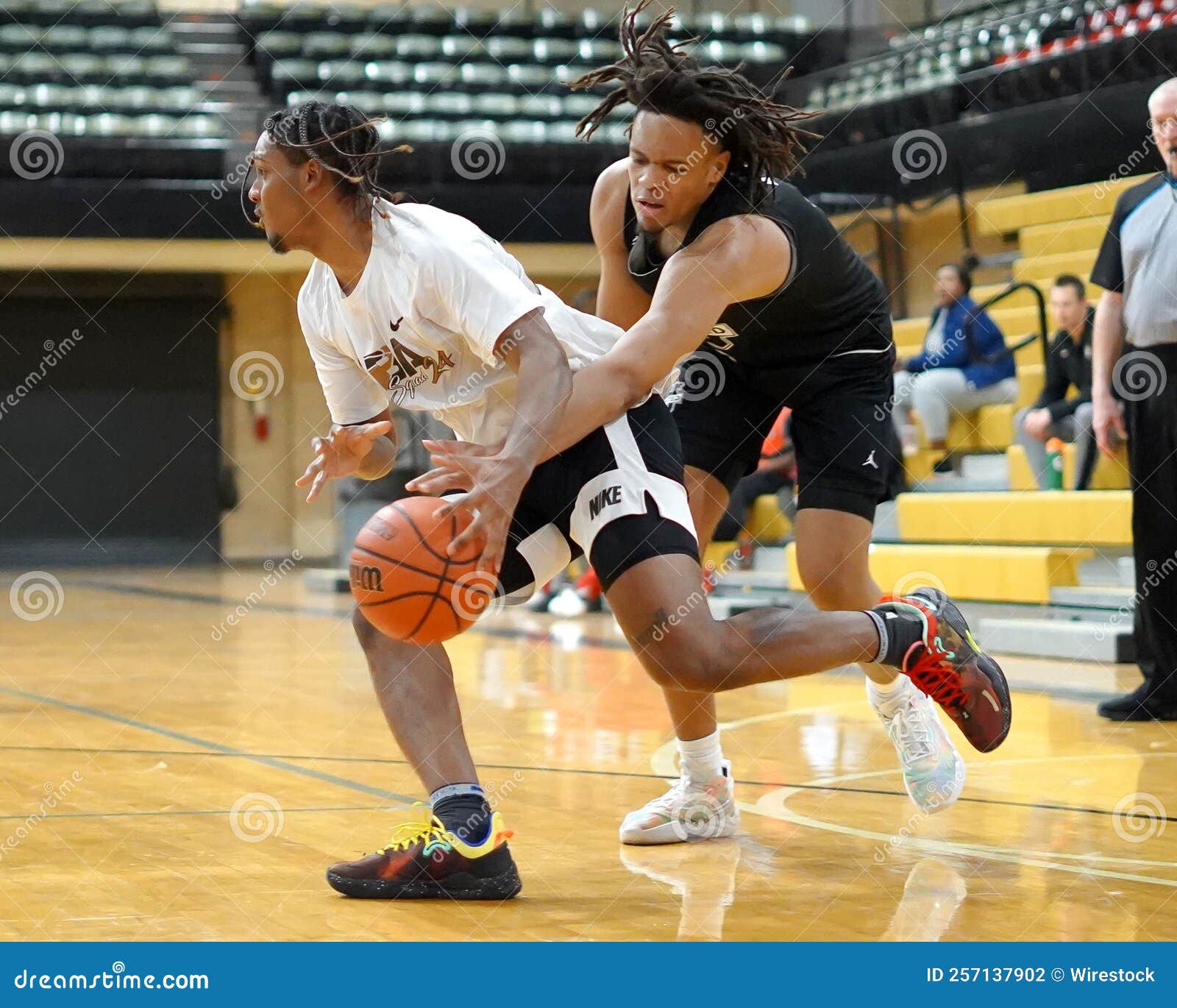 Basketball Player Dribbling the Ball into the Hoop Editorial