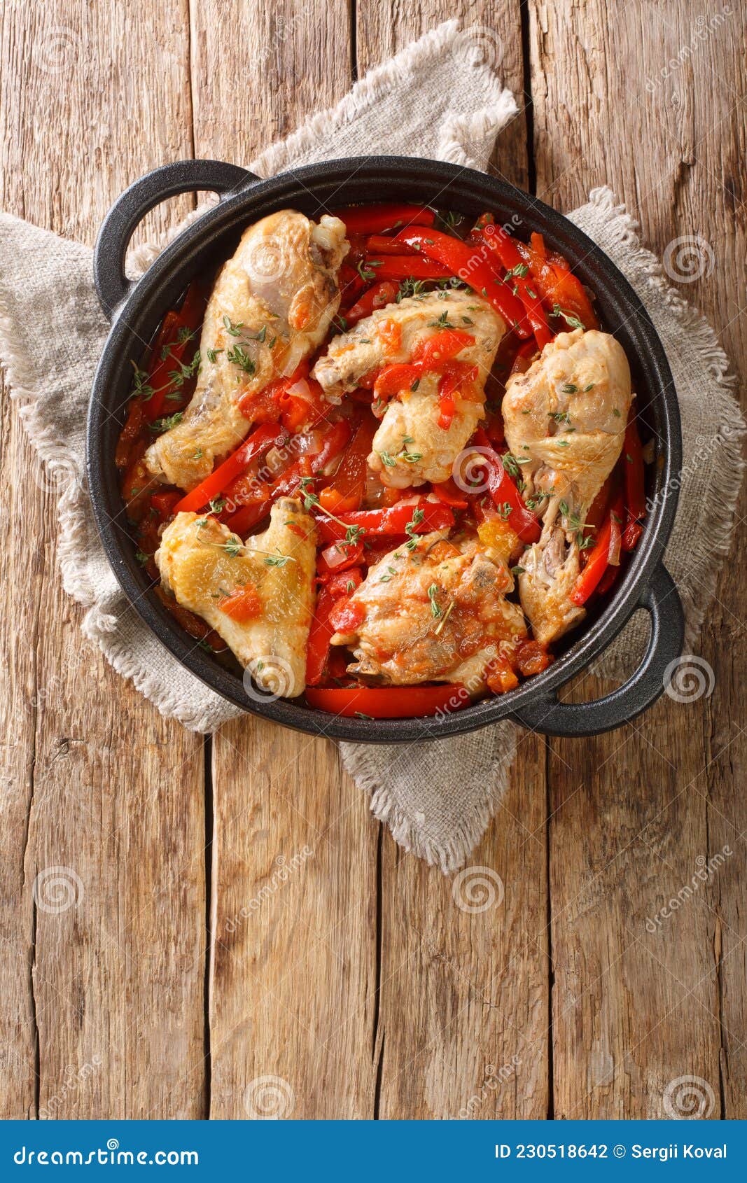basque style chicken with peppers close up in the pan. vertical top view