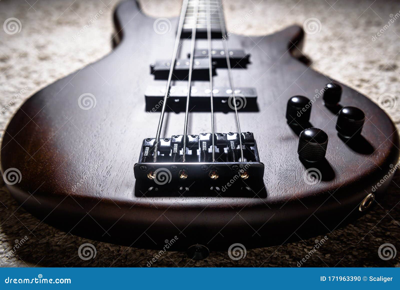 bass electric guitar with four strings closeup. detail of popular rock musical instrument. close view of bass, focus on bridge