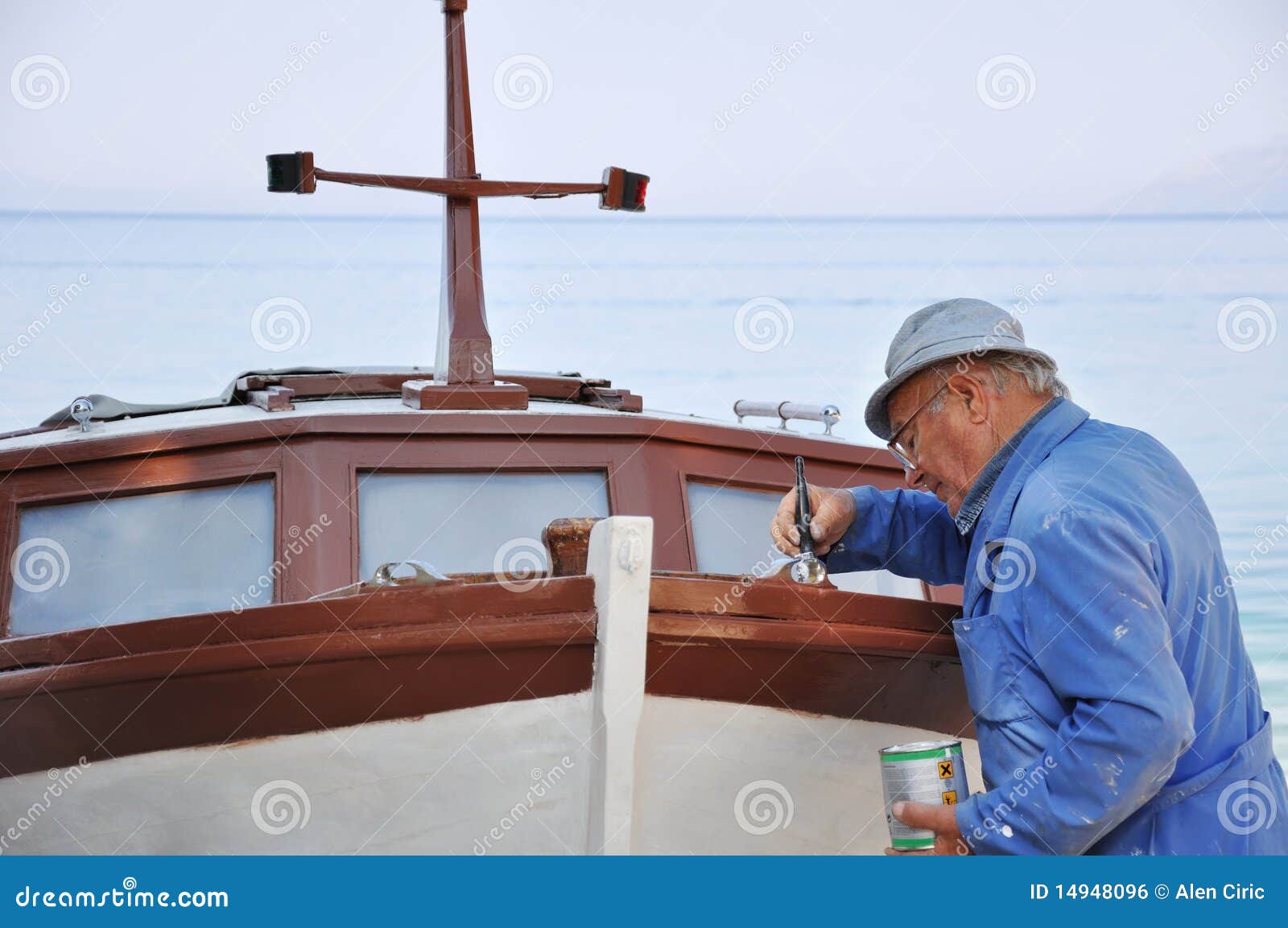 Bateau de peinture de vieil homme sur la plage