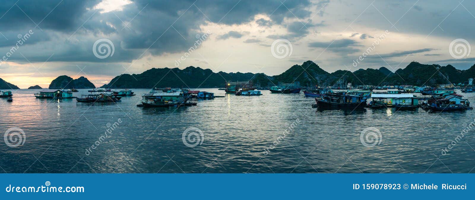 Bateau à la maison flottante sur l'île de Cat Ba Bateau de maison de pêcheurs amarré dans la baie devant la ville au coucher du s. Bateau à la maison flottante sur l'île de Cat Ba Bateau de la maison des pêcheurs amarré dans la baie devant la ville à la prise de pan au coucher du soleil