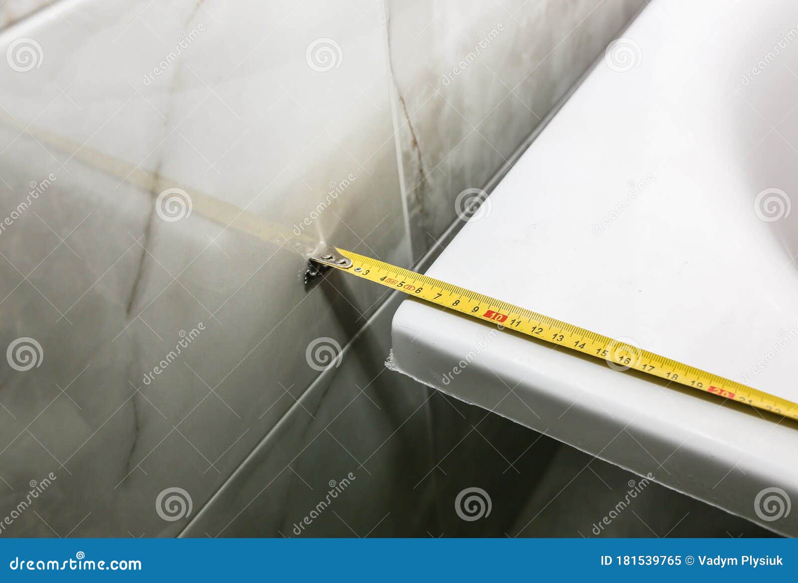 Bath Installation. Worker is Making Fastener with Measure Tape