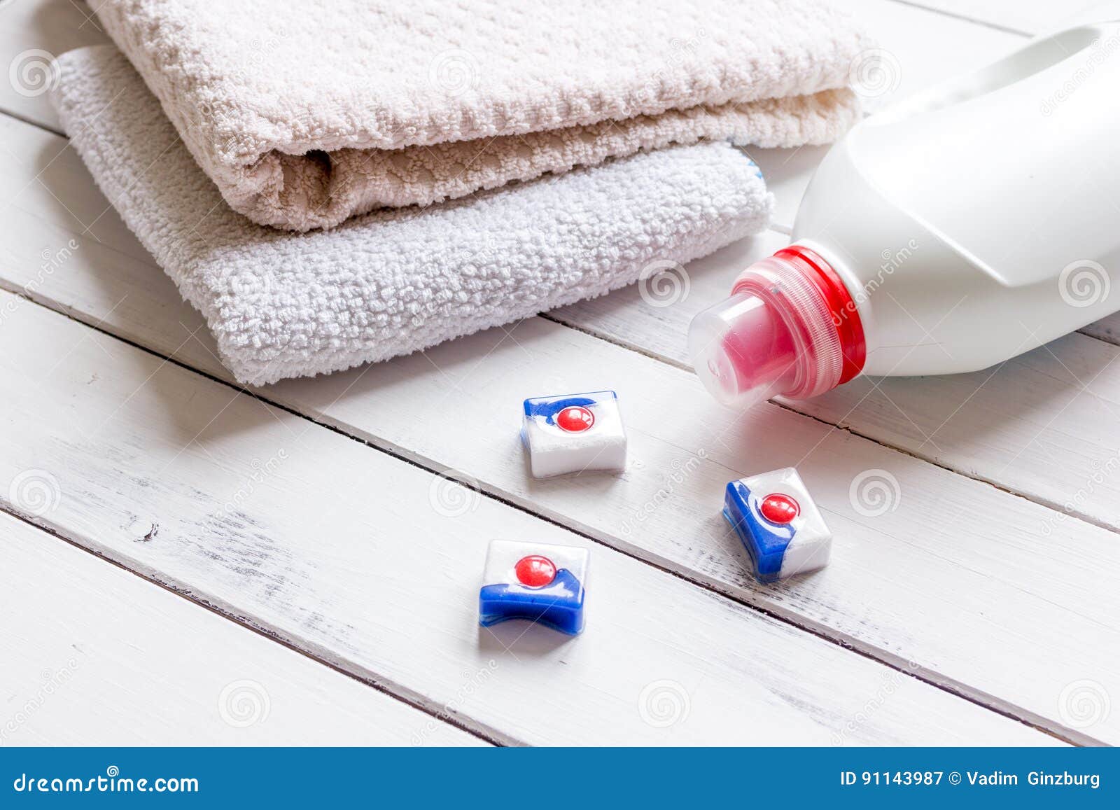 Bath Towels Stack with Detergent Bottle in Laundry Light Background