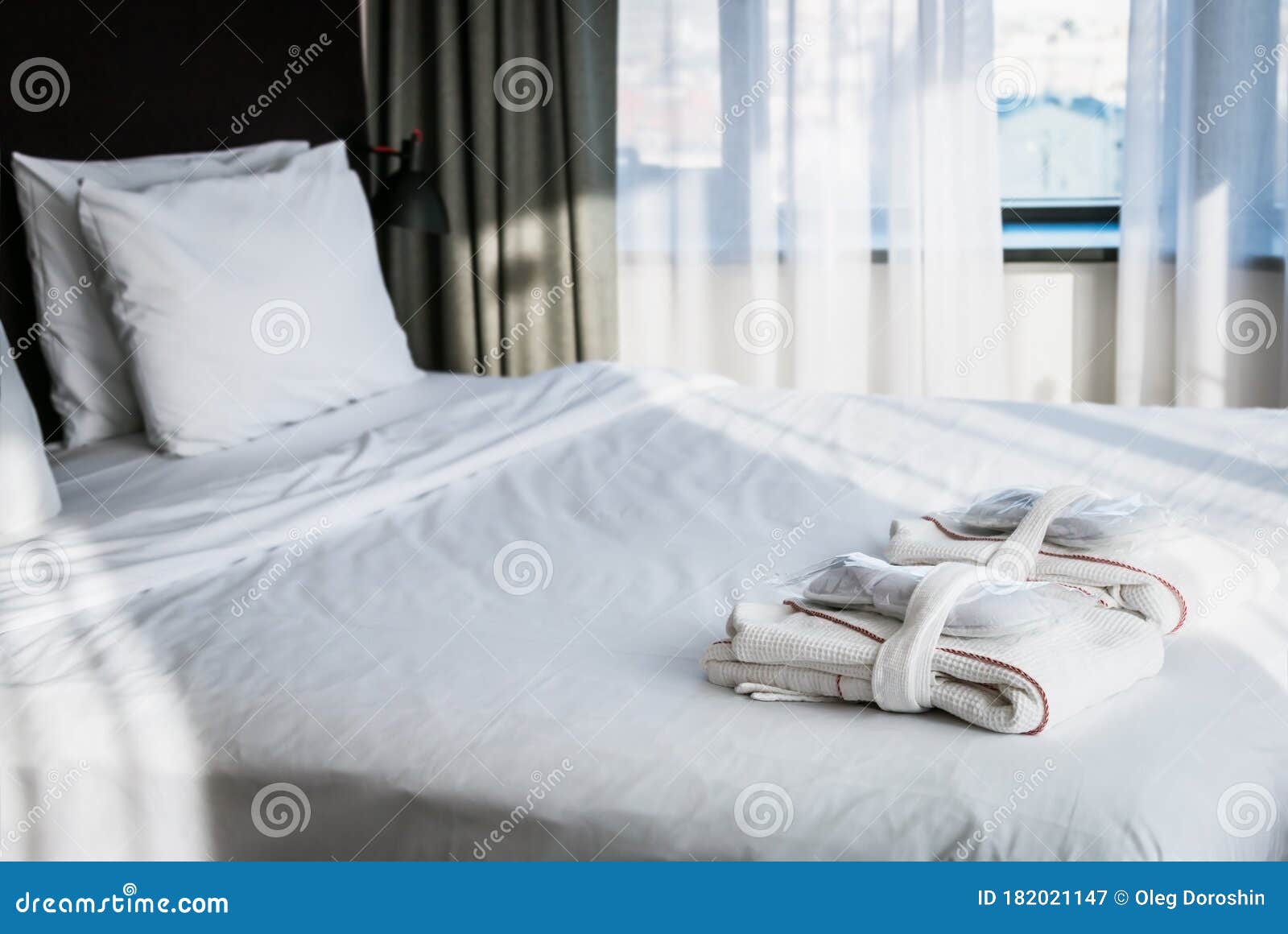 Bathrobe and Slippers are on the Bed in the Hotel Room Stock Image