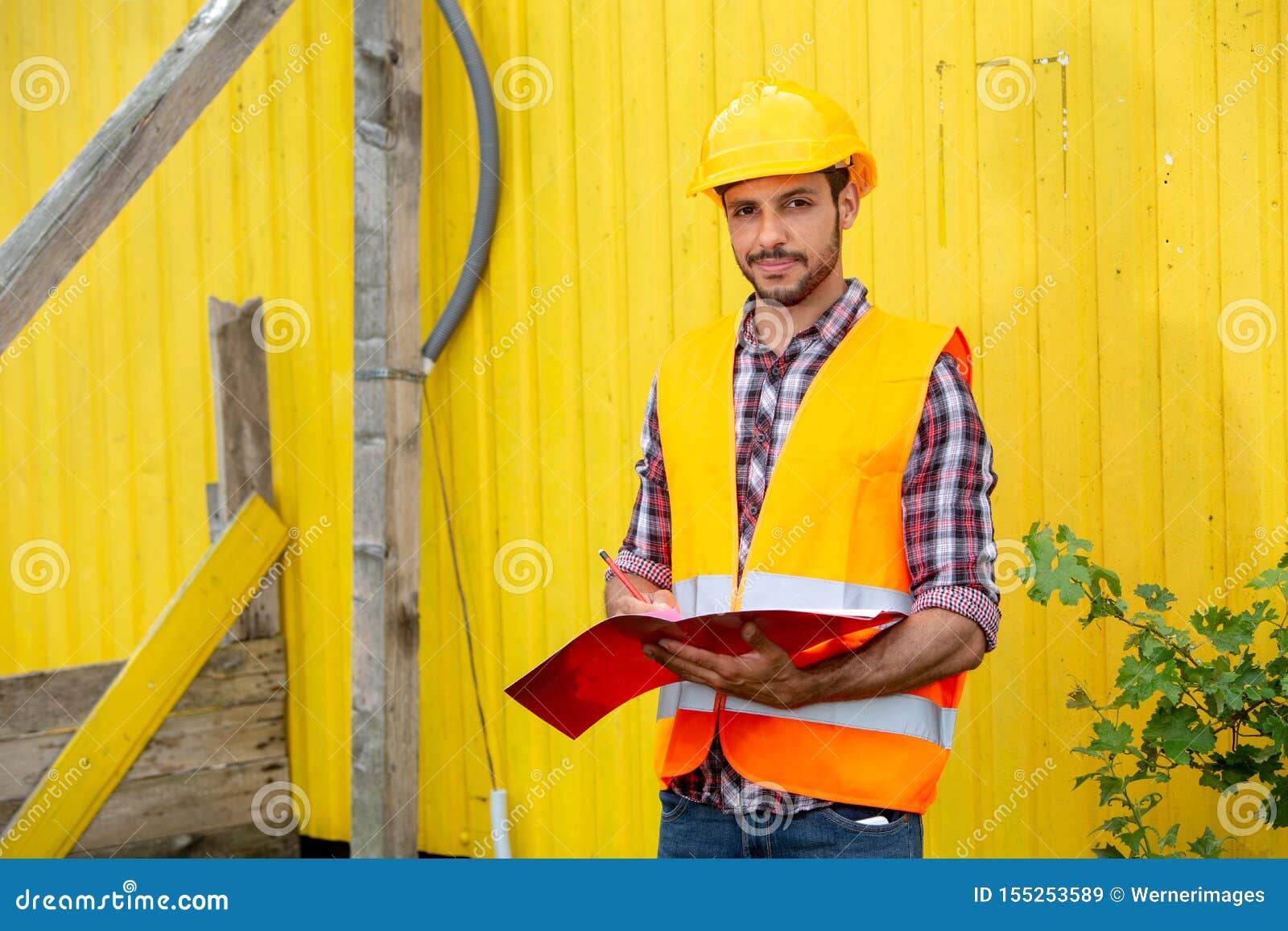 Bauarbeiter Mit Gelbem Sturzhelm Und Orange Weste Stockbild - Bild