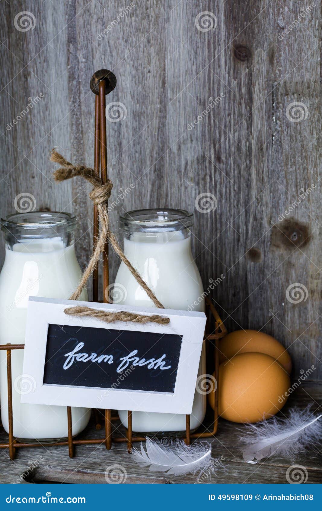 Frische Bauernhofmilch in den Glasgefäßen und in den Eiern auf hölzerner Tabelle