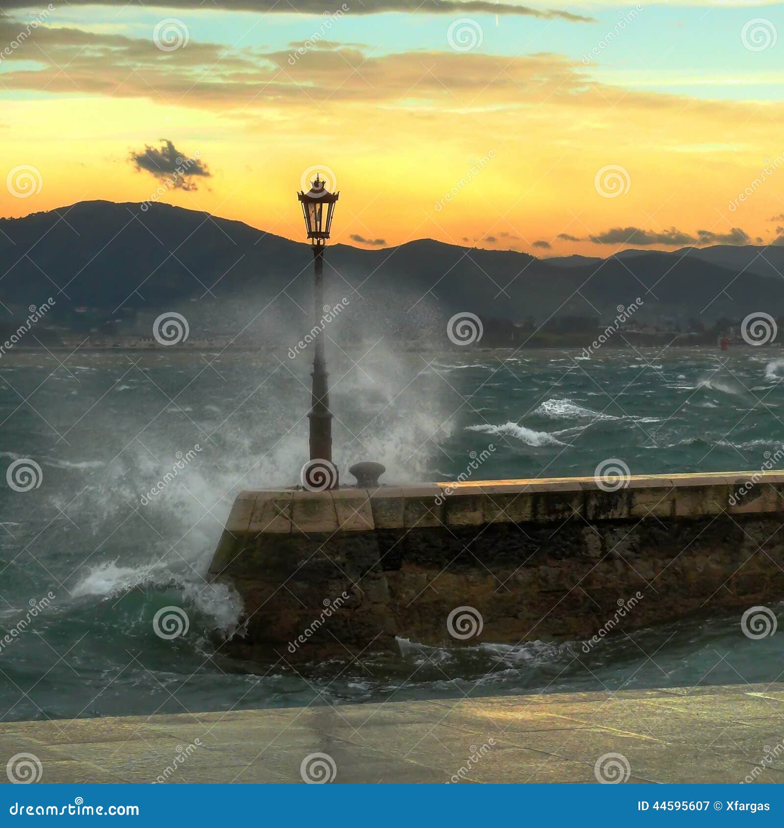 Bay strong waves. Street lamp detail with strong waves in the Santander Bay (Spain)