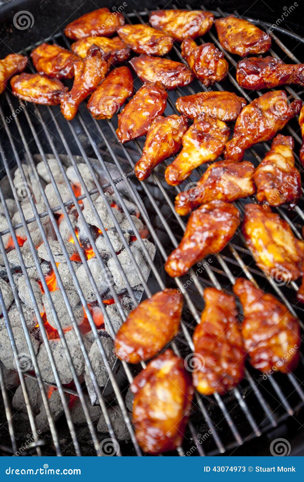 Sauced BBQ chicken wings over hot coals