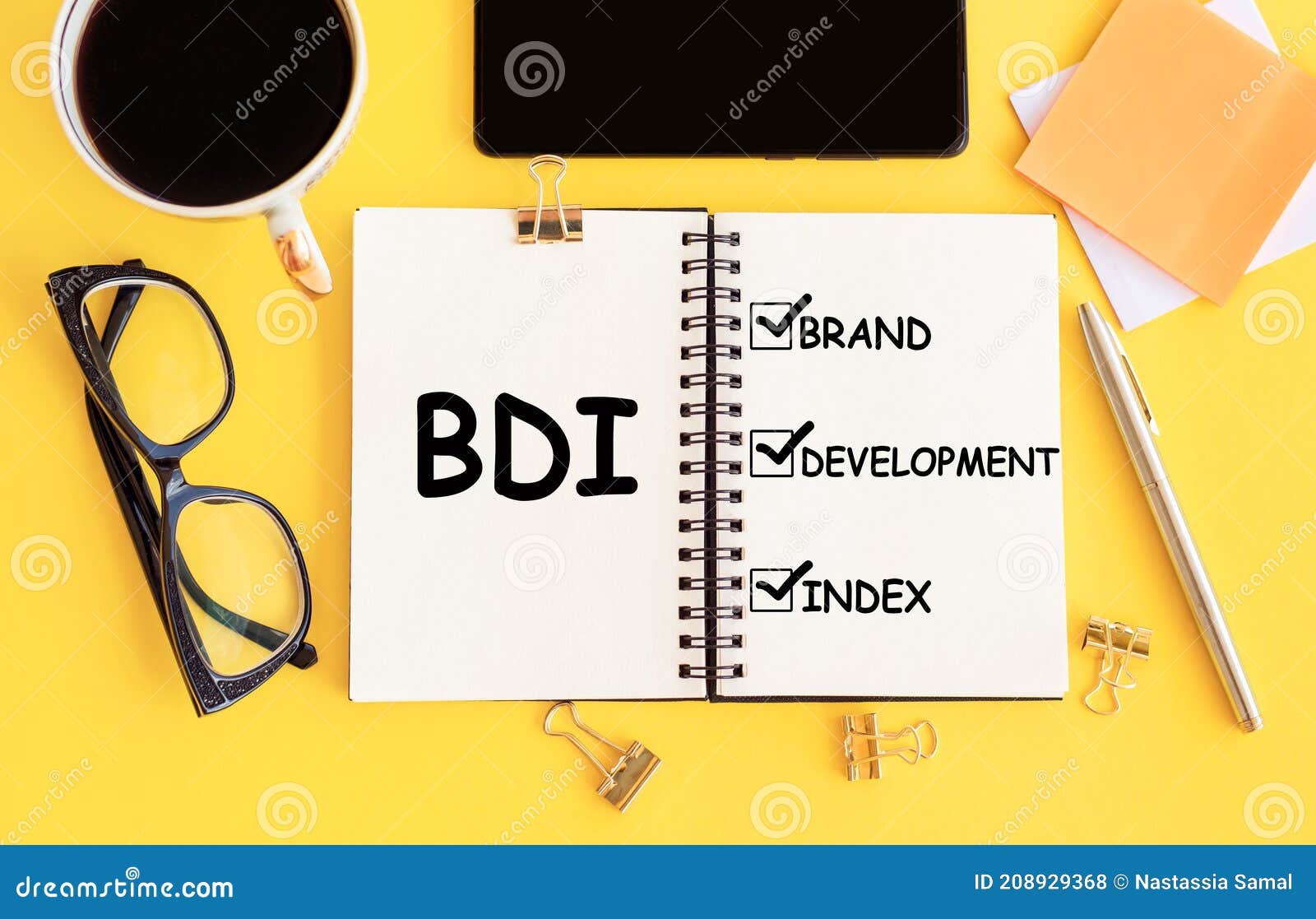 bdi - brand development index. text on notepad and office accessories on yellow desk