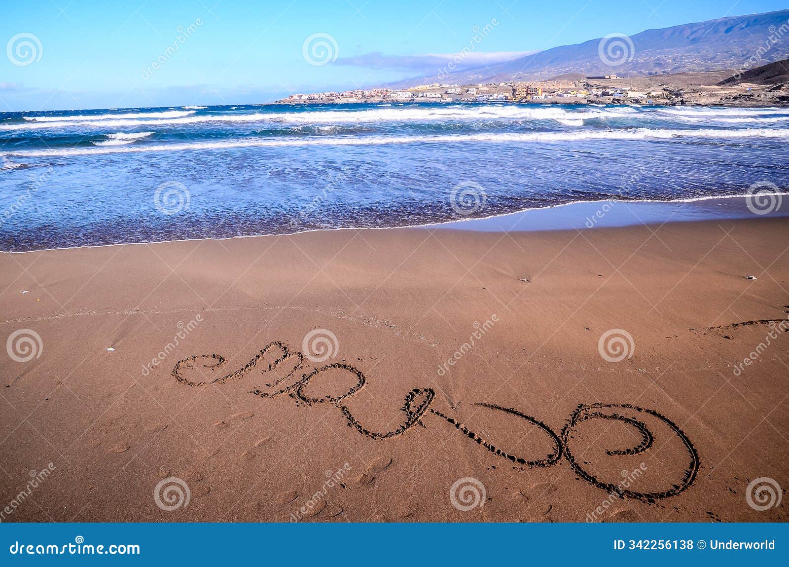 the beach is calm and peaceful, with the ocean waves gently lapping at the shore